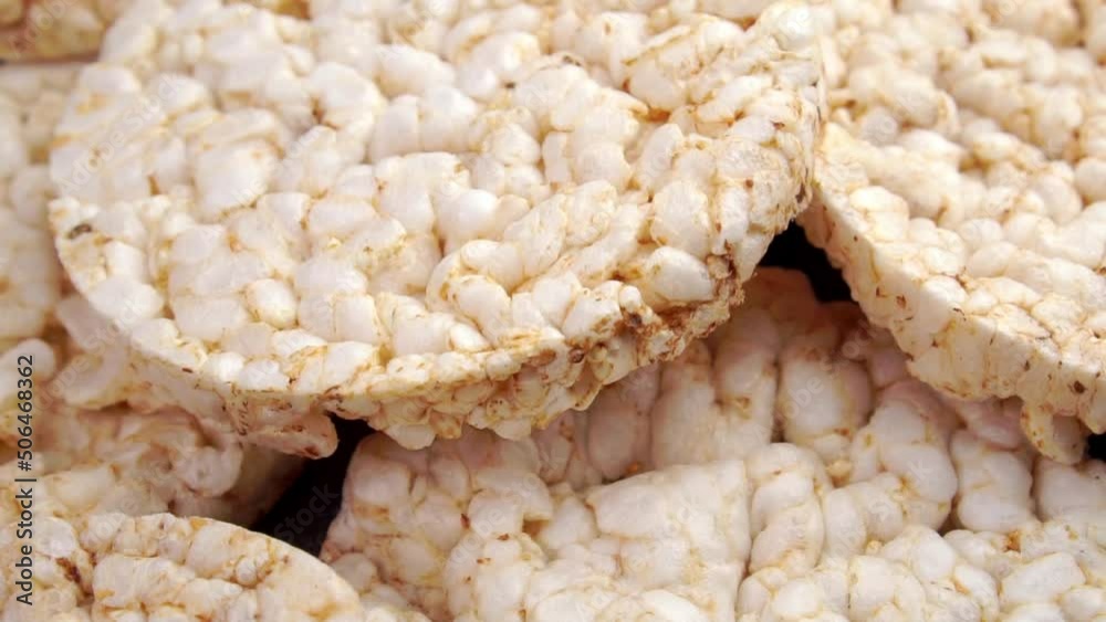 Crunchy dry rice cakes falling on a heap in slow motion. Healthy crispbread snack. Close up