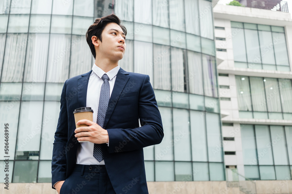 Image of Young asian businessman with glass building background Image of Young asian businessman with glass building background