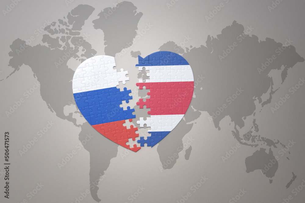 puzzle heart with the national flag of russia and costa rica on a world map background. Concept.
