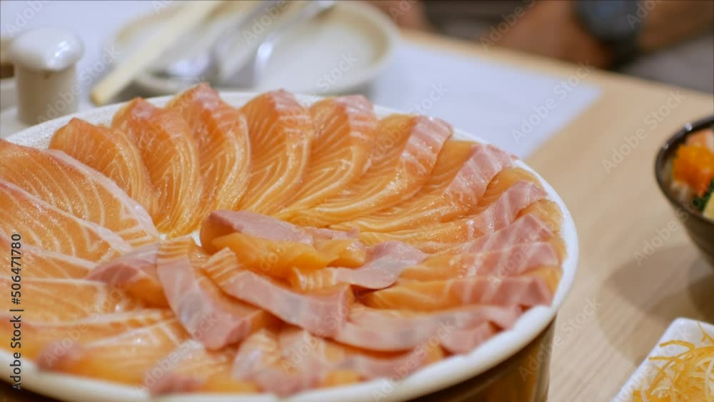4k video of using chopctick pick slamon up from plate full of salmon sashimi, raw fish Japanese style food. 4k video of using chopctick pick slamon up from plate full of salmon sashimi, raw fish Japanese style food.