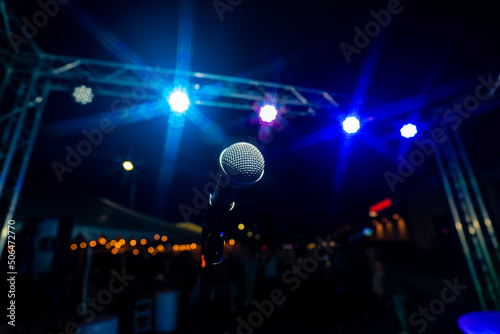 Comedy or Live Music Show at Night Outdoors with Microphone and Blue Lights Nightlife.