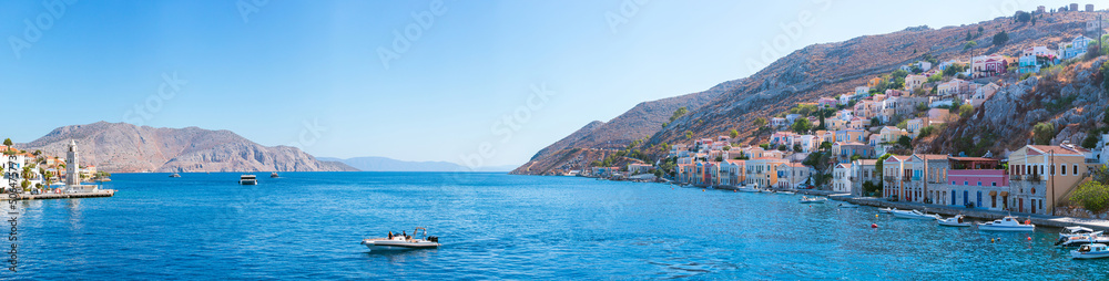 Big panorama view on Greek sea Symi island harbor port, houses on island hills.
