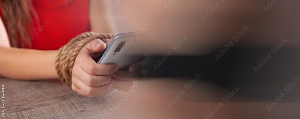 Obraz premium tied with a rope female hands hold the phone