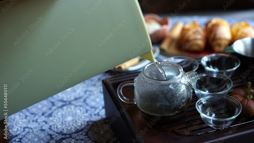 Traditional tea set tray with modern transparent pot and clear small cup in cozy Chinese room. Natural healthy hot clear drink with dried leaves give good aroma and relax for drink. Traditional tea set tray with modern transparent pot and clear small cup in cozy Chinese room. Natural healthy hot clear drink with dried leaves give good aroma and relax for drink.