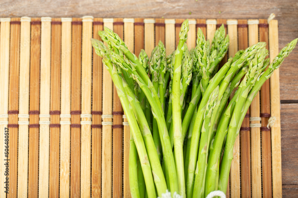 Asparagus is green and straight vegetable. Fresh, green asparagus is crispy for cook on wood table. Asparagus is green and straight vegetable. Fresh, green asparagus is crispy for cook on wood table.