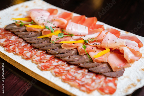 Plate with meat slices. Different types of meat ham and sausages top view.