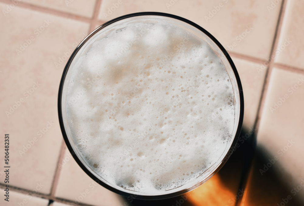 Glass of fresh lager beer with White fresh Foam on table. Beer foam top view. Bubble froth of beer Glass of fresh lager beer with White fresh Foam on table. Beer foam top view. Bubble froth of beer