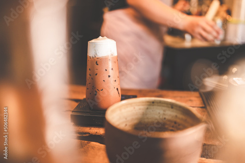professional barista making beverage chocolate drink from dark cocoa powder in brown mug with hot milk  having sweet aroma in cup at vintage cafe background in the morning breakfast