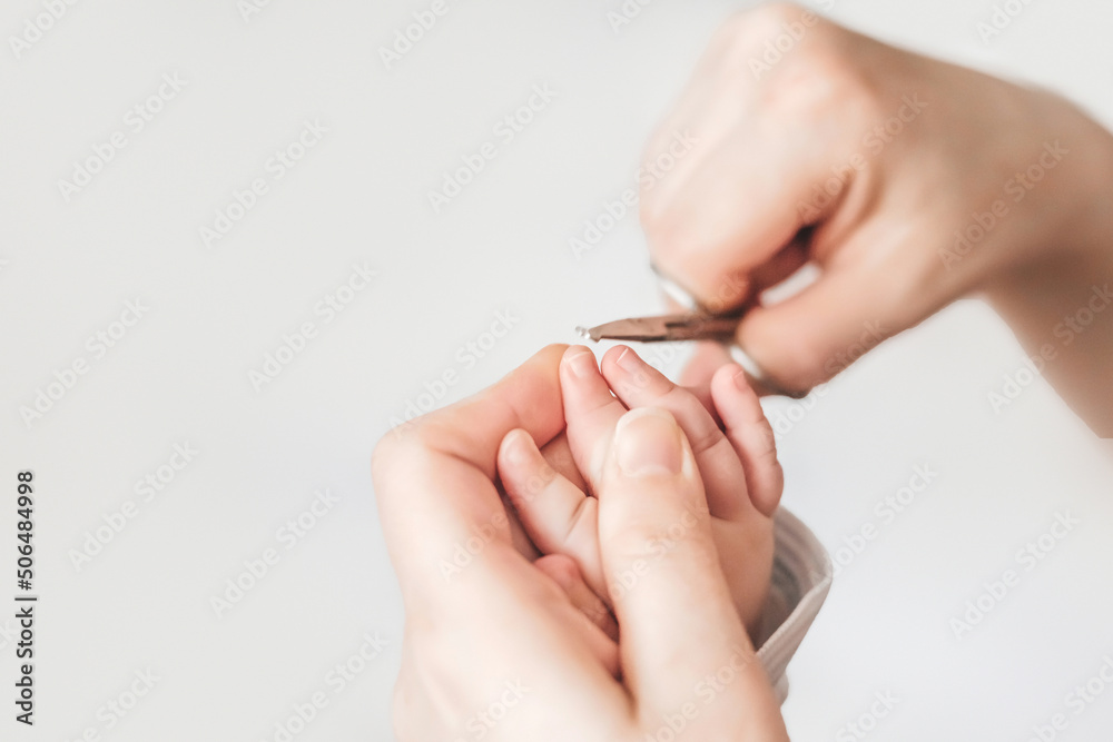 baby manicure. mom cuts baby's fingernails with special children's scissors. close up. copy space. manicure for newborns. white background baby manicure. mom cuts baby's fingernails with special children's scissors. close up. copy space. manicure for newborns. white background