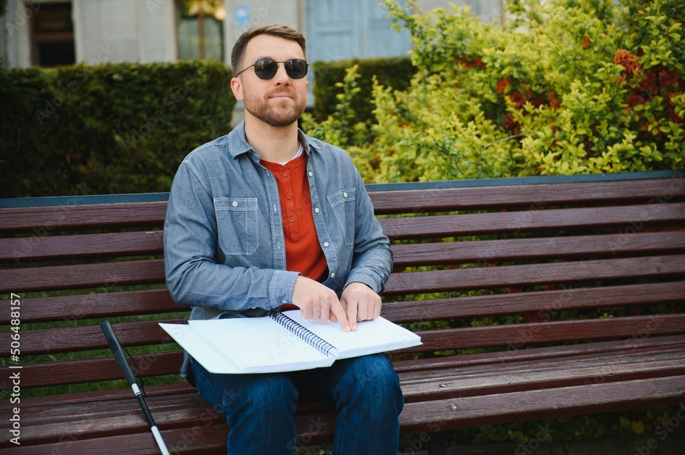 Fototapeta premium Blinded man reading by touching braille book