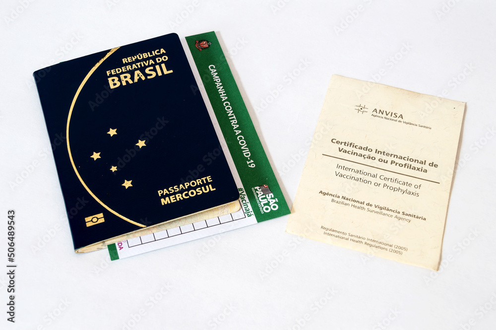 Two vaccination cards together with passport on a white table Two vaccination cards together with passport on a white table