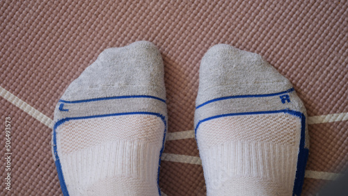 Male feet in socks standing on yoga mat closeup top view