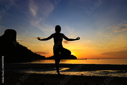 Fototapeta Naklejka Na Ścianę i Meble -  Silhouette young female practice Yoga on the beach , healthy lifestyle on beach side