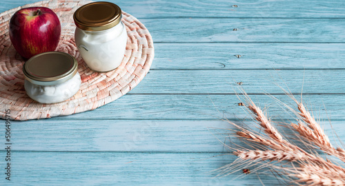Wheat ears and wicker straw stand with diary product photo