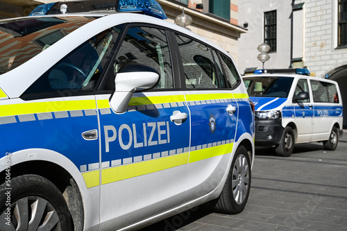 German police cars on the street. Side view of a police car with the lettering "Polizei". Police patrol car parked on the street in Germany.