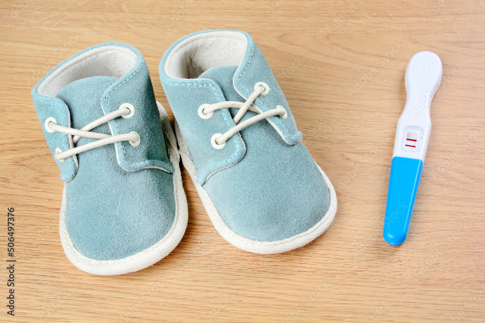 Blue shoes with pregnancy test on a table