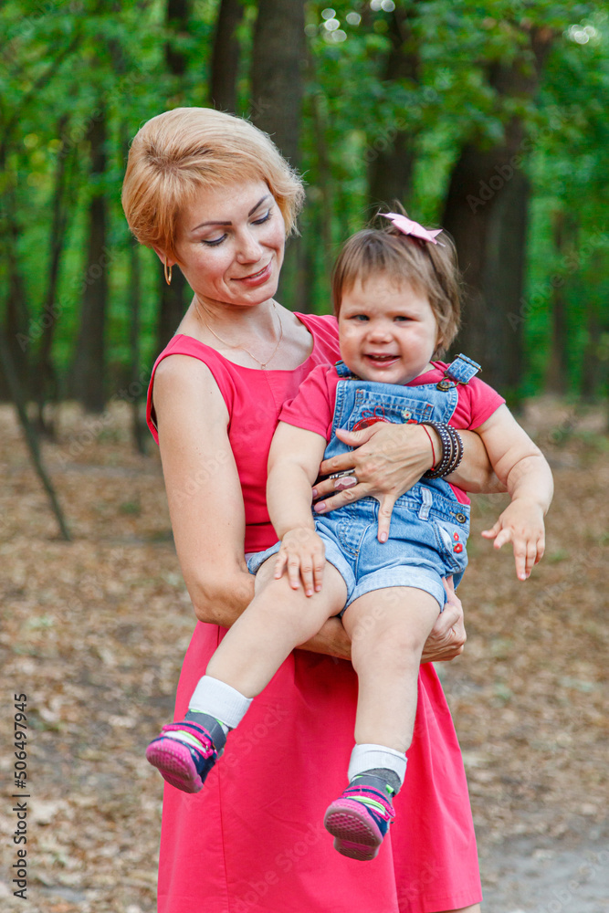 Fototapeta premium beautiful mother with her daughter walks in the park in summer
