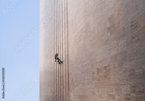 Window cleaner is working on the office building facade