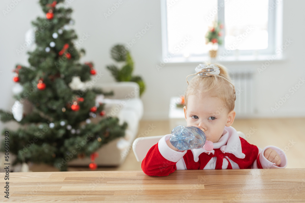 Child girl dressed in christmas dress with cochlear implants having fun at home - diversity and hearing aid and innovating technologies for treatment of deafness. Copy space and place for advertising Child girl dressed in christmas dress with cochlear implants having fun at home - diversity and hearing aid and innovating technologies for treatment of deafness. Copy space and place for advertising