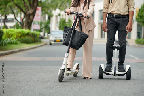 IT company workers riding on company campus on electric scooters