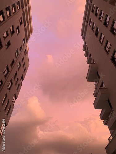 Zachód słońca w mieście. Symetryczne wieżowce na tle różowego nieba. 