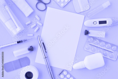 Very pery the color of the year 2022. Top view of medical instruments: syringe, vaccine, pills, bandage, thermometer, workplace of medical personnel, an empty card with a place for text. photo