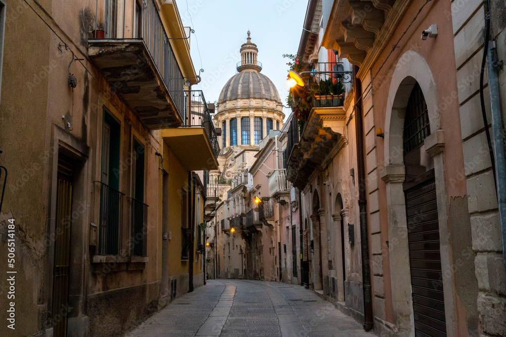 Mediterranean city on the island of Sicily, with a church dome at the end of the street