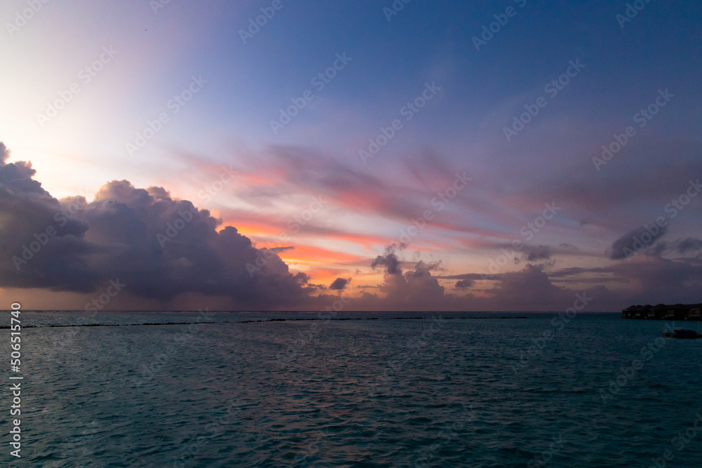 Maldives sunset with pink colors and reddish clouds