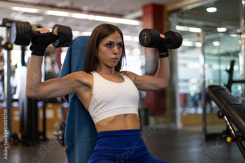 woman training with dumbbells at the gym