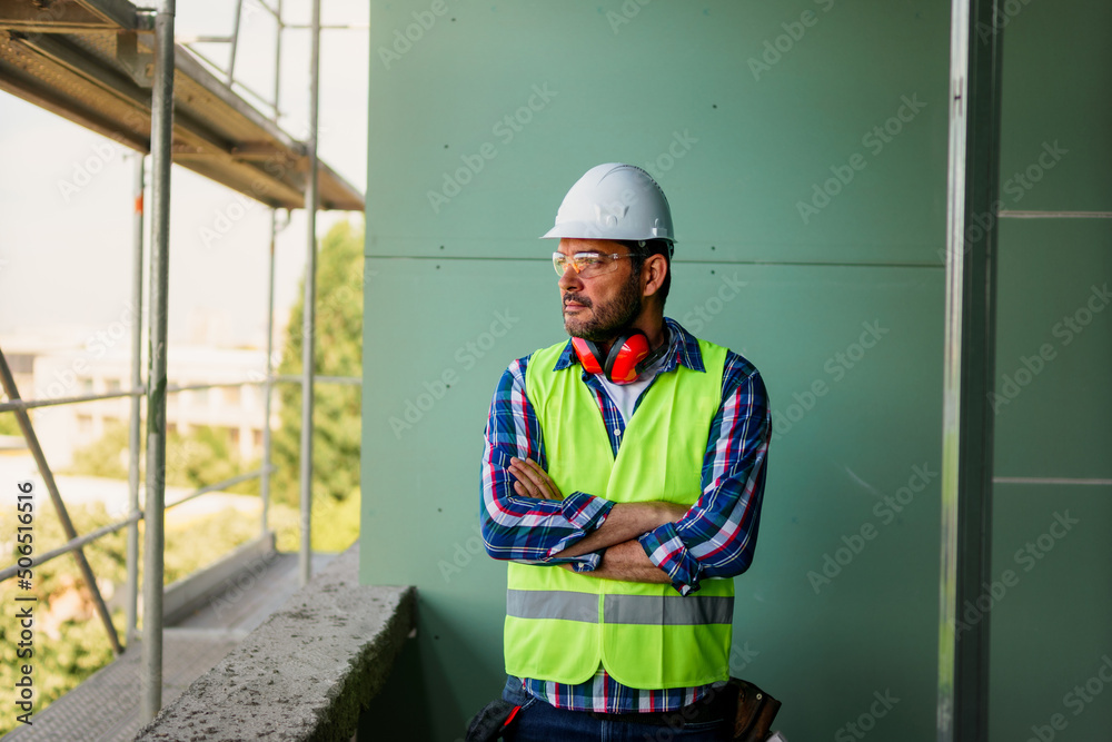 Portrait of men in 40s, construction worker. He is standing in construction and posing for camera. Portrait of men in 40s, construction worker. He is standing in construction and posing for camera.