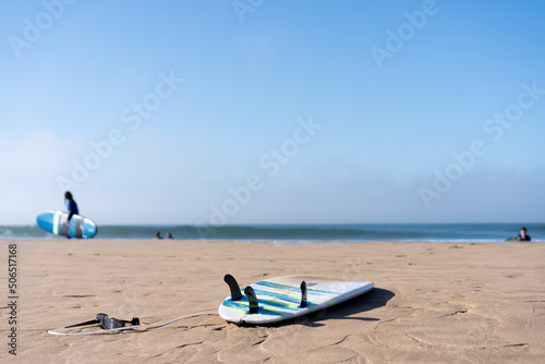 Serf board on the beach. View of nice Atlantic ocean beach with sand ,blue sea and blue sky. Holiday and vacation concept. photo