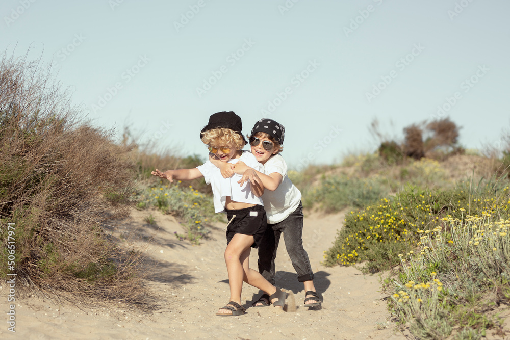 Carefree little kids hugging and playing on beach on sunny day Carefree little kids hugging and playing on beach on sunny day