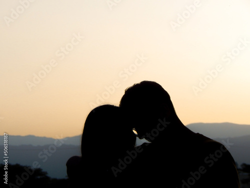 silhouette of couple kissing on sunset © Nicolas