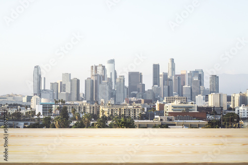 Blank wooden table top with beautiful Los Angeles skyline at daytime on background  mockup