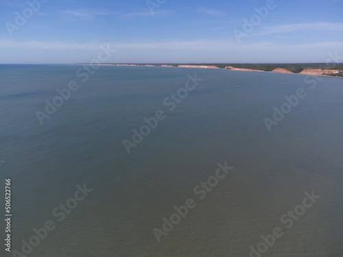 Ocean at low tide showing corals  rocks and small fishing boats in Bahia  Brazil  South America  Atlantic Ocean