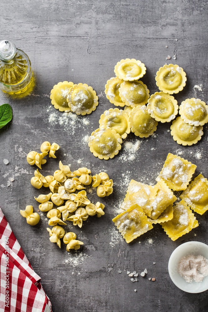 Fototapeta premium different types of fresh raw italian ravioli on the table with cooking ingredients. home kitchen