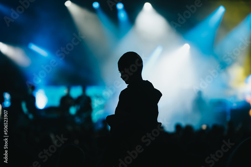 Silhouette of a child in a audience crowd on a concert