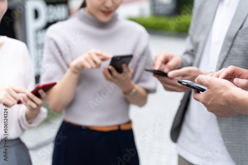 屋外でスマートフォンを使う人の手元 photo