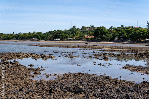 Ocean at low tide showing corals, rocks and small fishing boats in Bahia, Brazil, South America, Atlantic Ocean photo