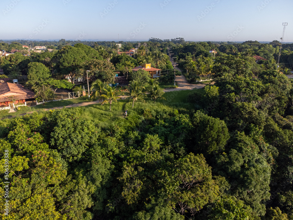 Wonderful city in the middle of the forest and Atlantic ocean with beautiful beach and low tide showing the corals - Cumuruxatiba, Bahia, Brazil - aerial drone view. Wonderful city in the middle of the forest and Atlantic ocean with beautiful beach and low tide showing the corals - Cumuruxatiba, Bahia, Brazil - aerial drone view.