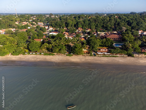 Wonderful city in the middle of the forest and Atlantic ocean with beautiful beach and low tide showing the corals - Cumuruxatiba, Bahia, Brazil - aerial drone view. photo