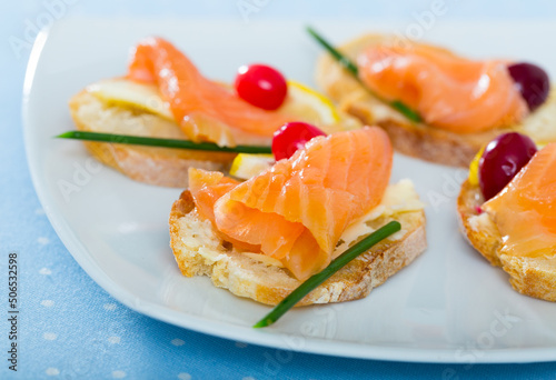 Image of exquisitely served tasty bruschettes with salmon, butter and cranberries