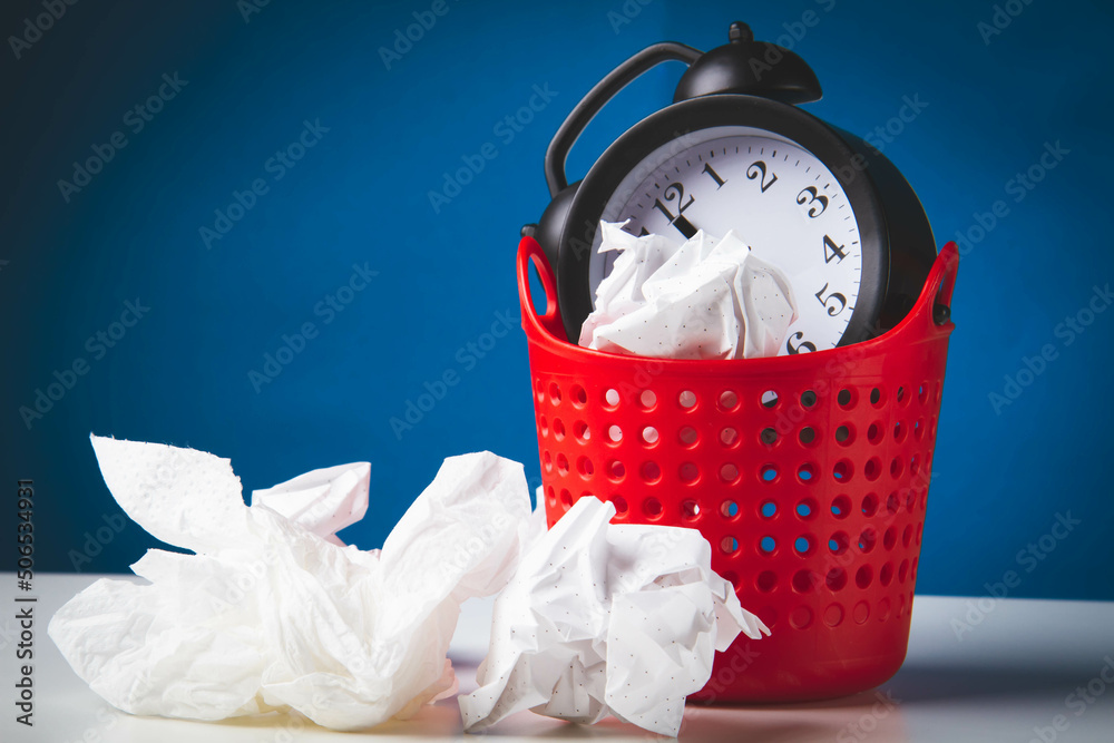 Early rise. Alarm clock in the trash. Woke up. Clock in the trash can. Stock Photo Adobe Stock