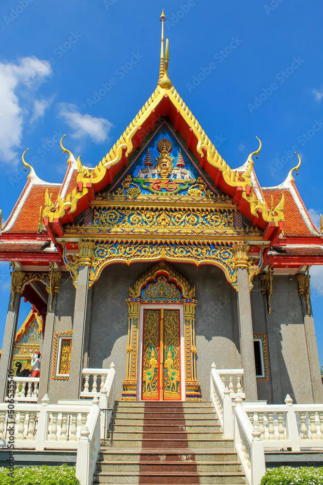 Front entrance and stairs of the Thai buddhist temple in Phuket, Thailand. Blue sky, copy space for text, wallpaper, golden, red, green, blue, background
