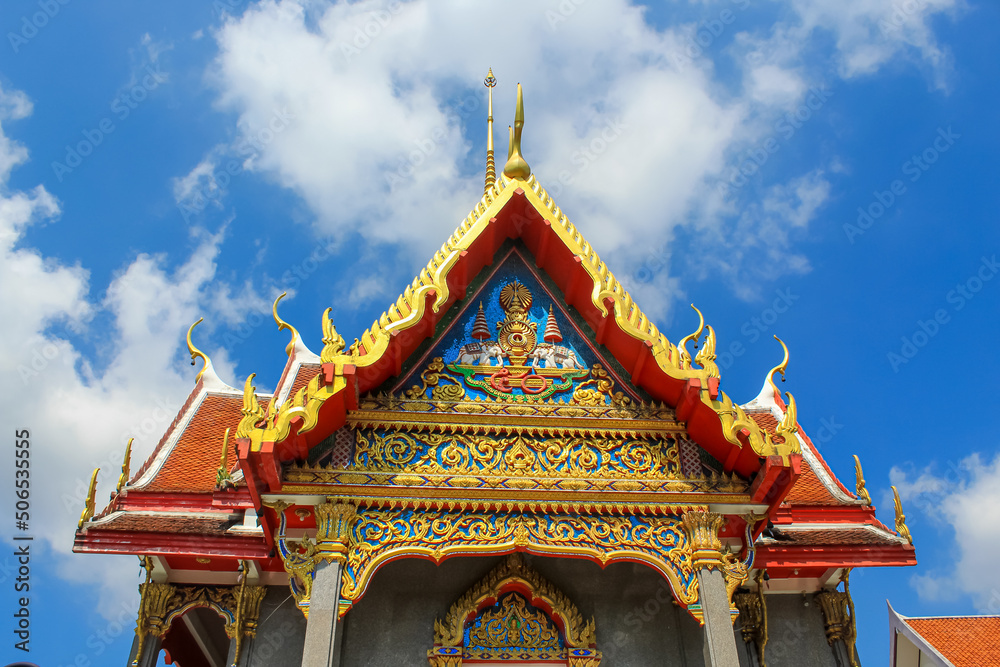 Entrance decoration of the Thai buddhist temple in Phuket, Thailand. Blue sky, copy space for text, wallpaper, golden, red, green, blue, background