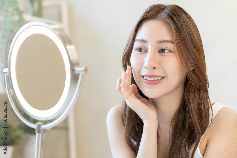Fresh, nice healthy skin, beautiful of asian young woman, girl looking at mirror, touching her face with before make up cosmetic routine at home. Female look with natural fashion style, Facial Beauty. Fresh, nice healthy skin, beautiful of asian young woman, girl looking at mirror, touching her face with before make up cosmetic routine at home. Female look with natural fashion style, Facial Beauty.