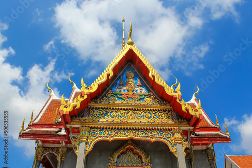 Entrance decoration of the Thai buddhist temple in Phuket  Thailand. Blue sky  copy space for text  wallpaper  golden  red  green  blue  background