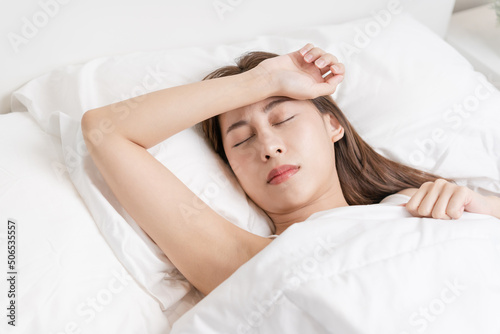 Sweet dreams, attractive smile pretty asian young woman, girl sleeping in comfortable bed lying on soft pillow resting, keeping eyes closed while with covered blanket in cozy white bed in the morning.
