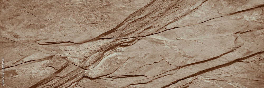 Light brown rock texture. Rough mountain surface. Close-up. Beige stone background with space for design. Web banner. Wide. Panoramic. Sandstone. Solid, rocky, slate.