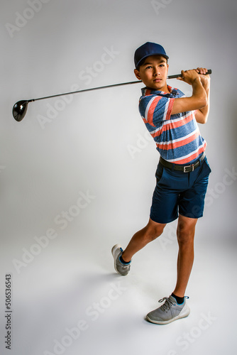 Young male golfer watching the ball after teeing off